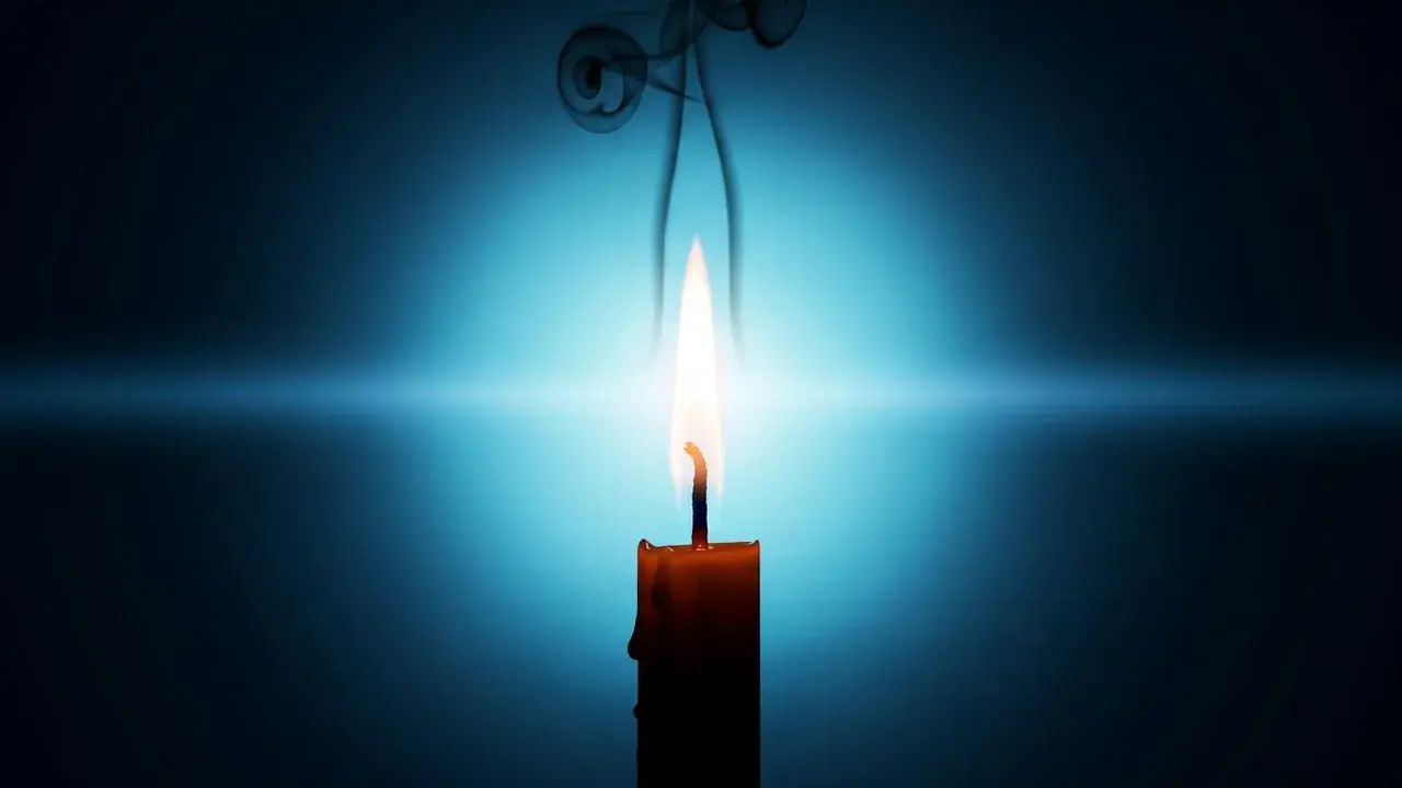 A nearly-spent candle in deep darkness, its flame surging tall and impossibly clear one final time, casting a brief halo of light before going out.